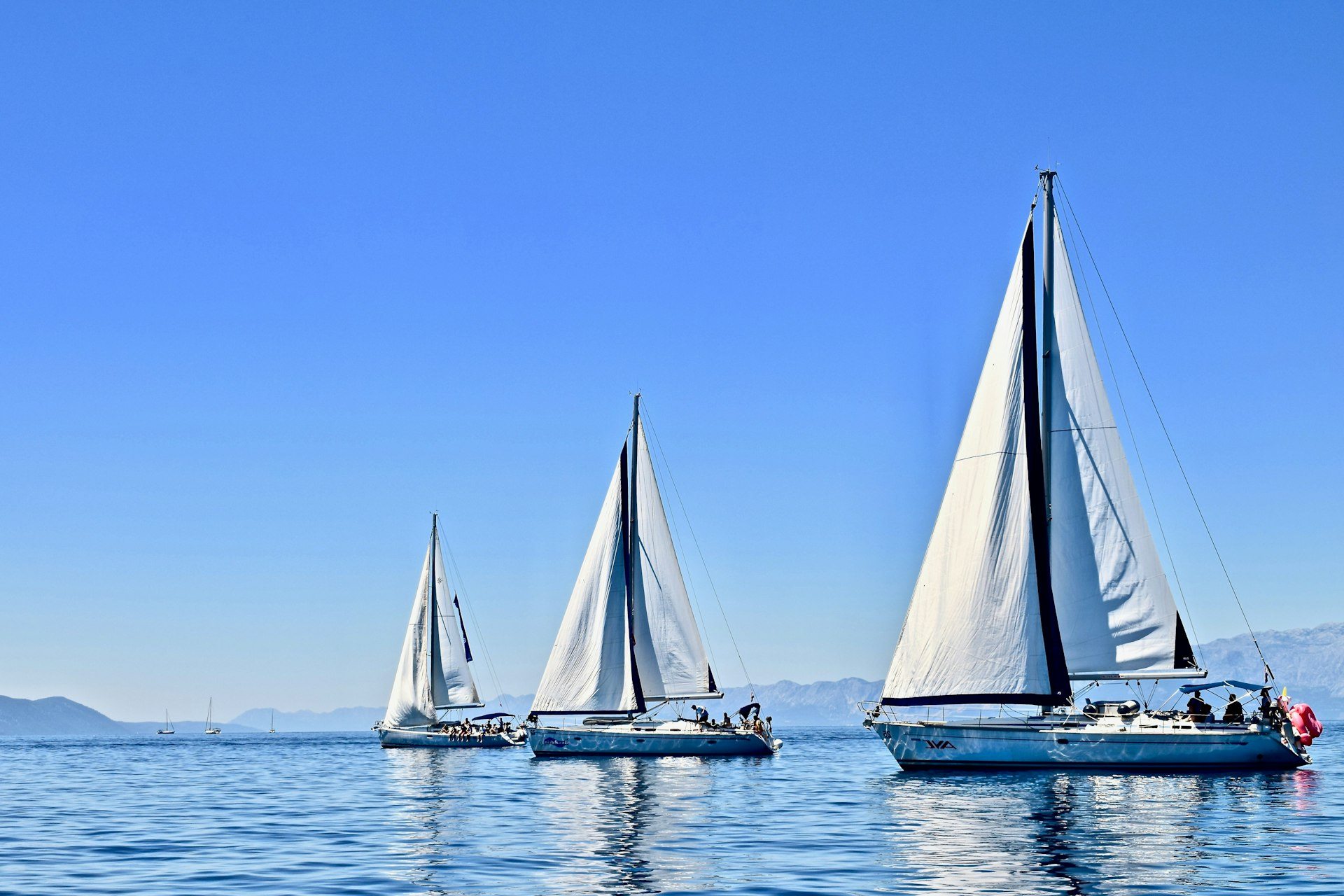 Trois voiliers toutes voiles dehors sur une mer calme